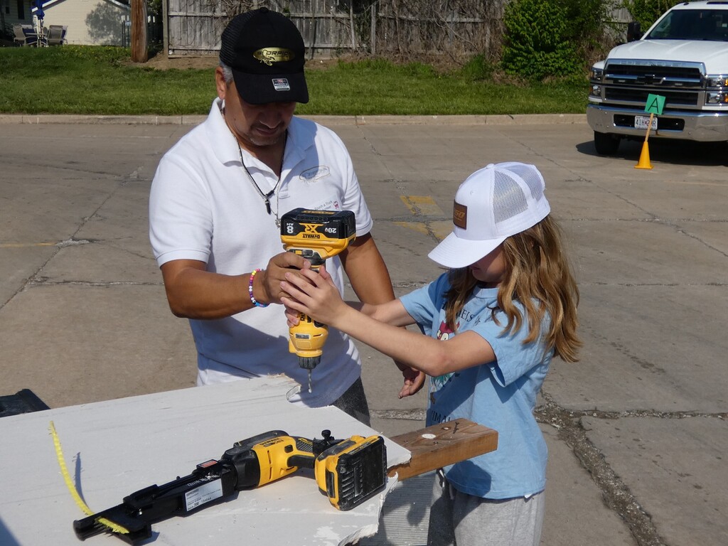 With presenter demos power drill with student getting hands on experience.