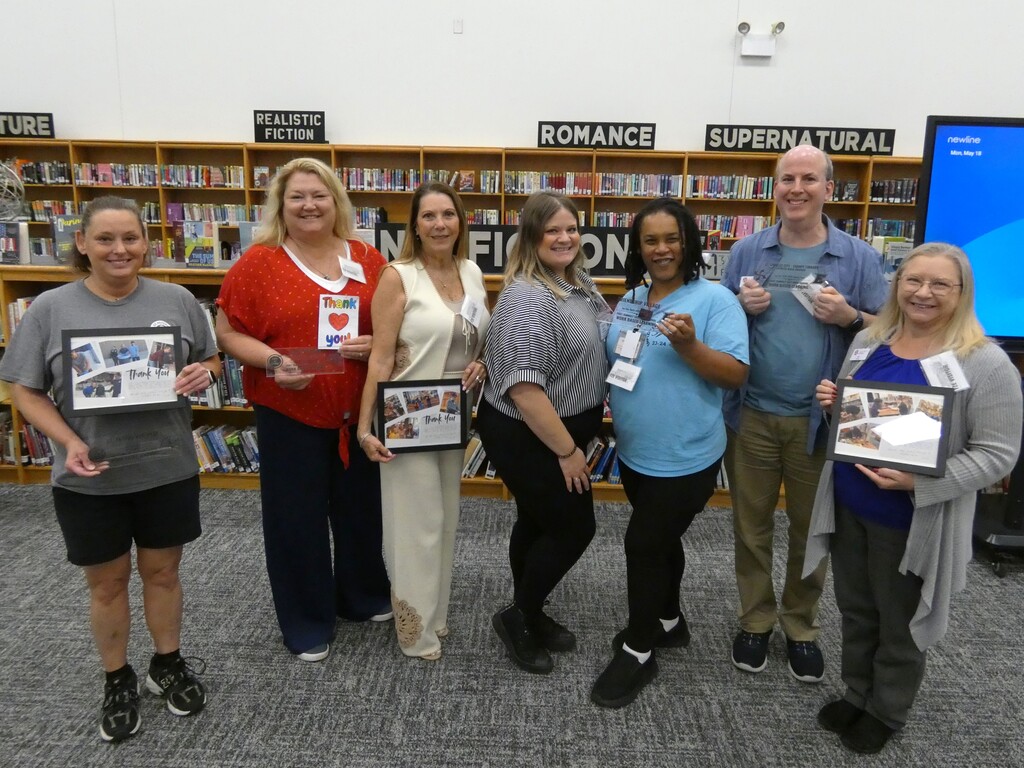 Business partners pose with certificates