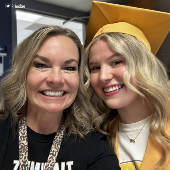 Teacher poses with former student in cap and gown