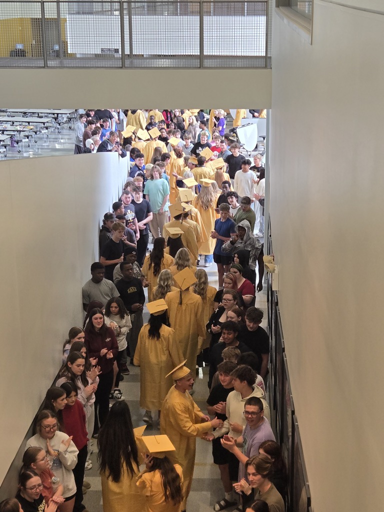 Grads file through lined hallway to high fives