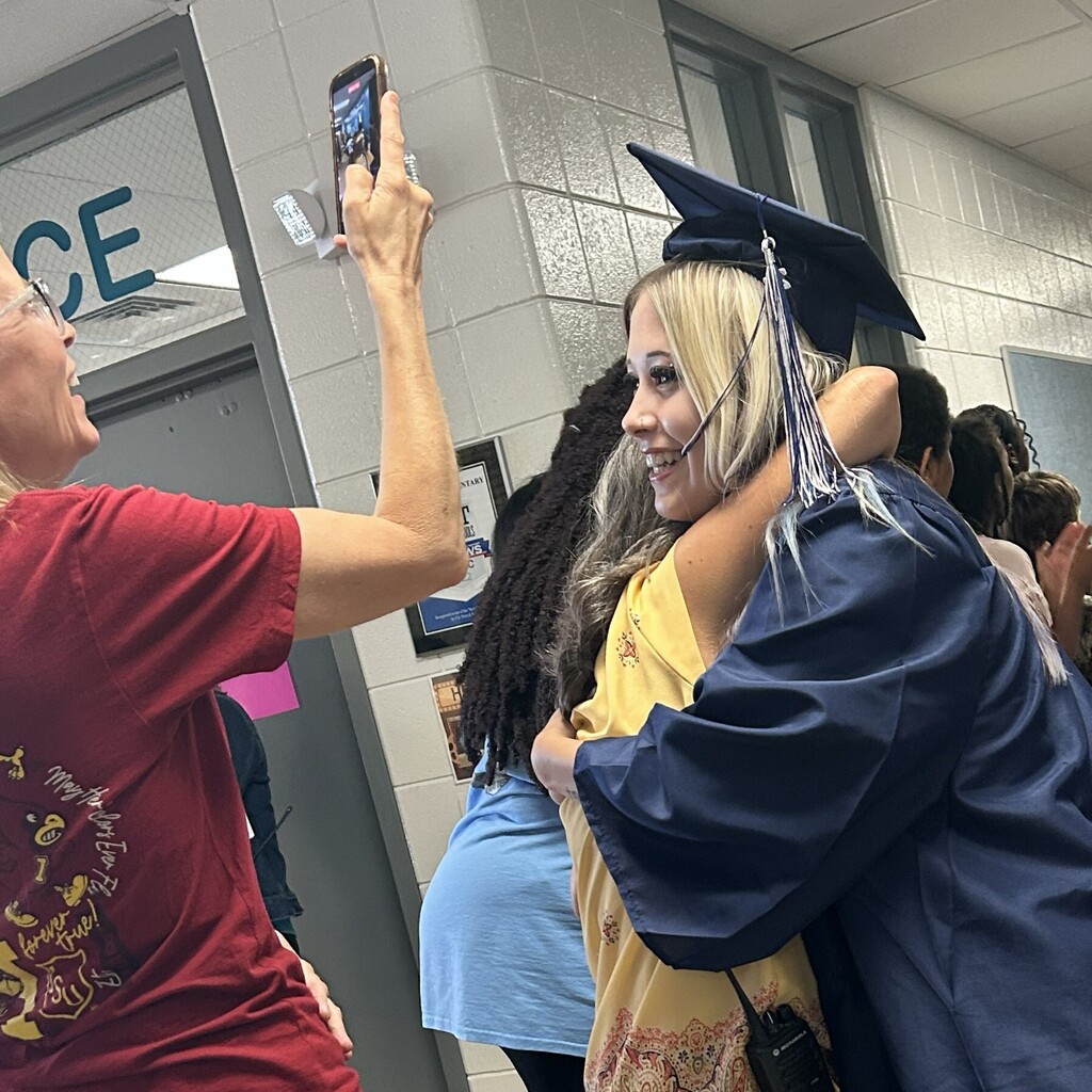 grad hugs former teacher
