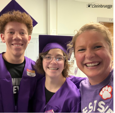 teacher takes a selfie with former students in caps and gowns