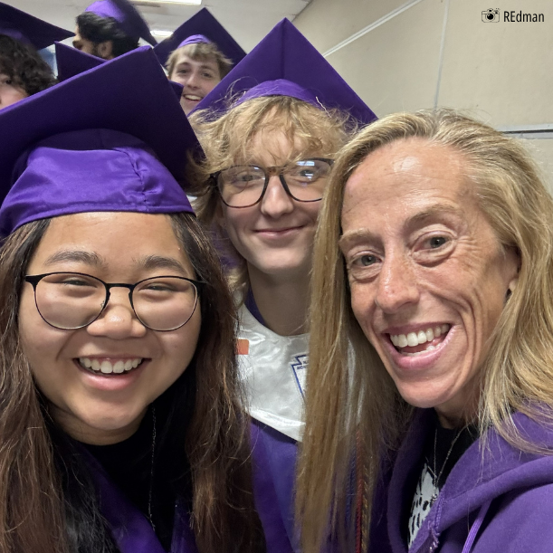 teacher takes a selfie with former students in caps and gowns