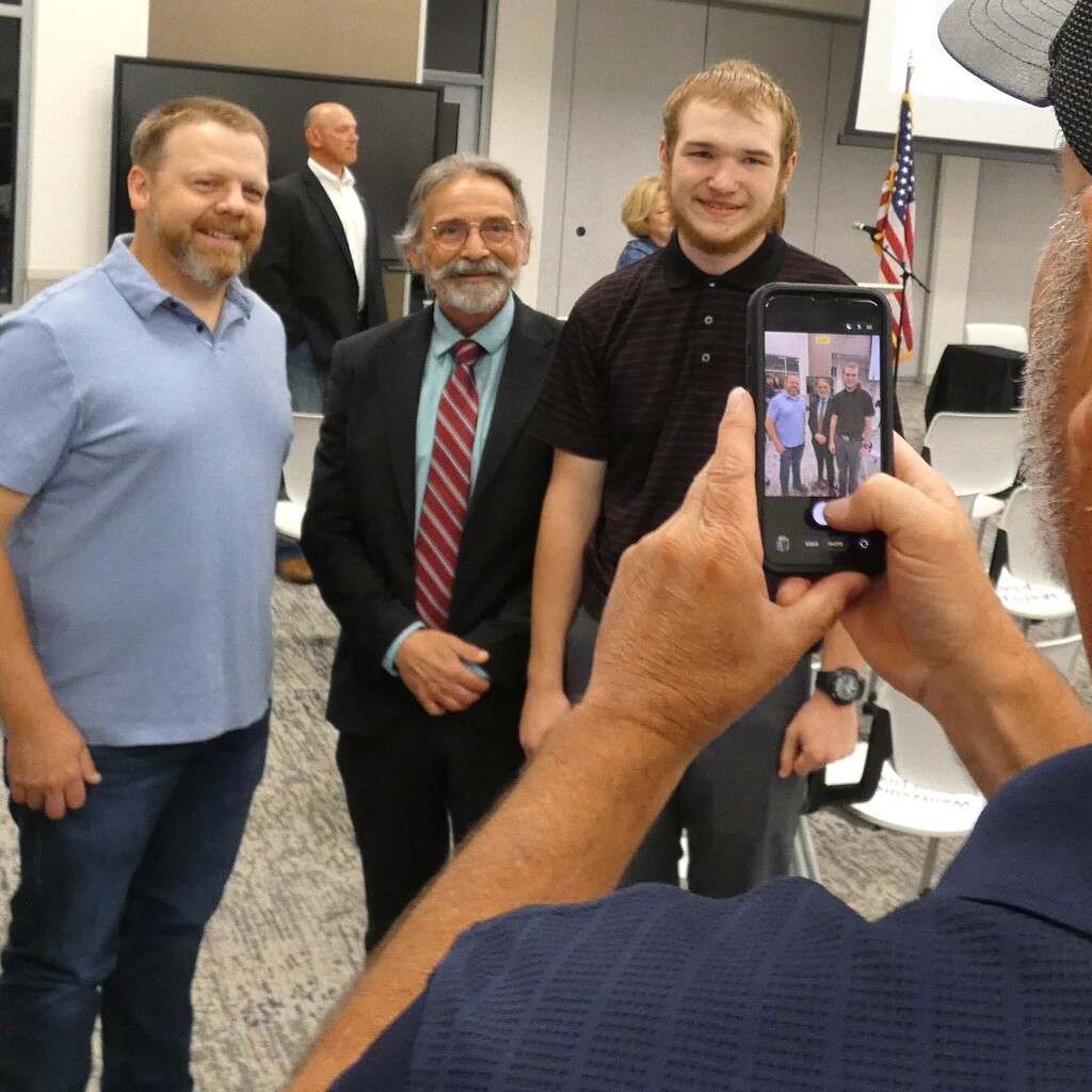 Families take pictures of new apprentices with reps from business partners