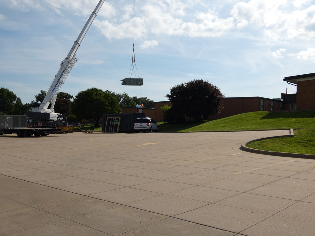 Crane hoists HVAC unit onto roof of North Middle