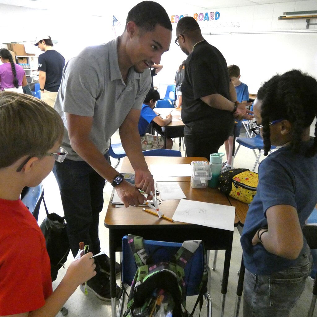 GM rep works with students to problem solve grabber design