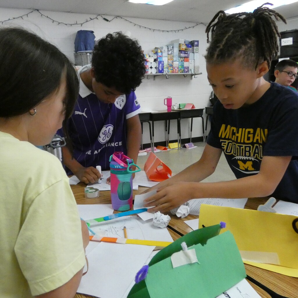 team members refer to drawing as they assemble grabber