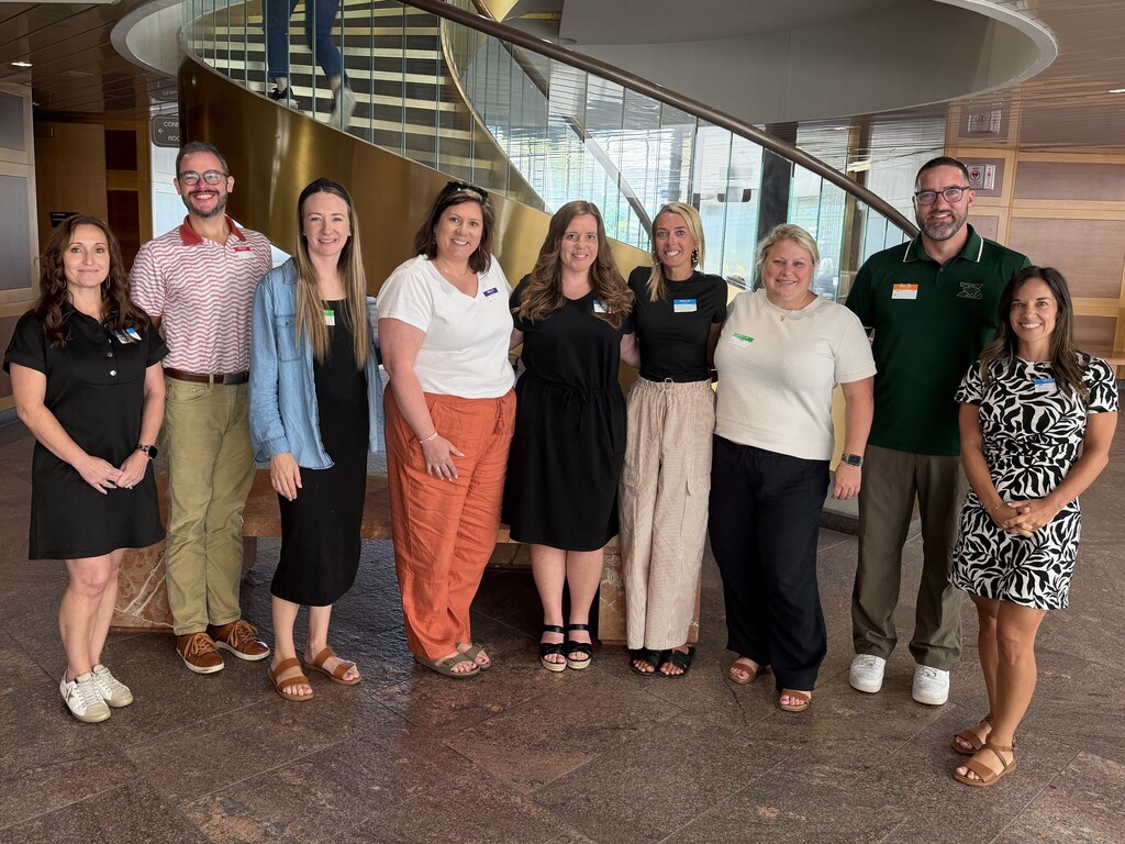 9 FZ administrators pause during professional development to pose for a photo