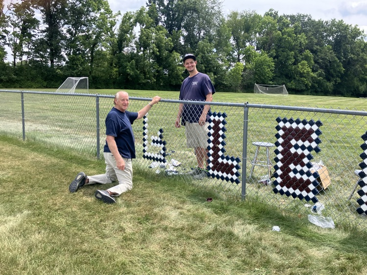 custodians working putting up fence sign