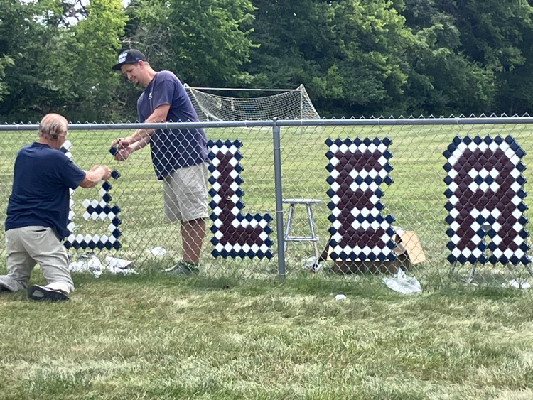 custodians working putting up fence sign