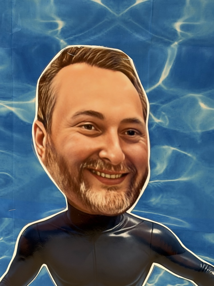 Mr. Johnson dressed as a surfer in a black wet suit