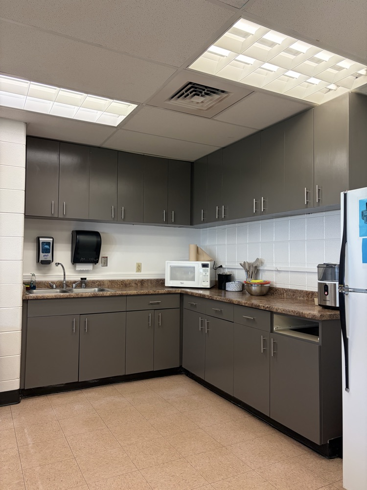 kitchen cabinets painted gray; a microwave, toaster, and nugget ice machine on counter