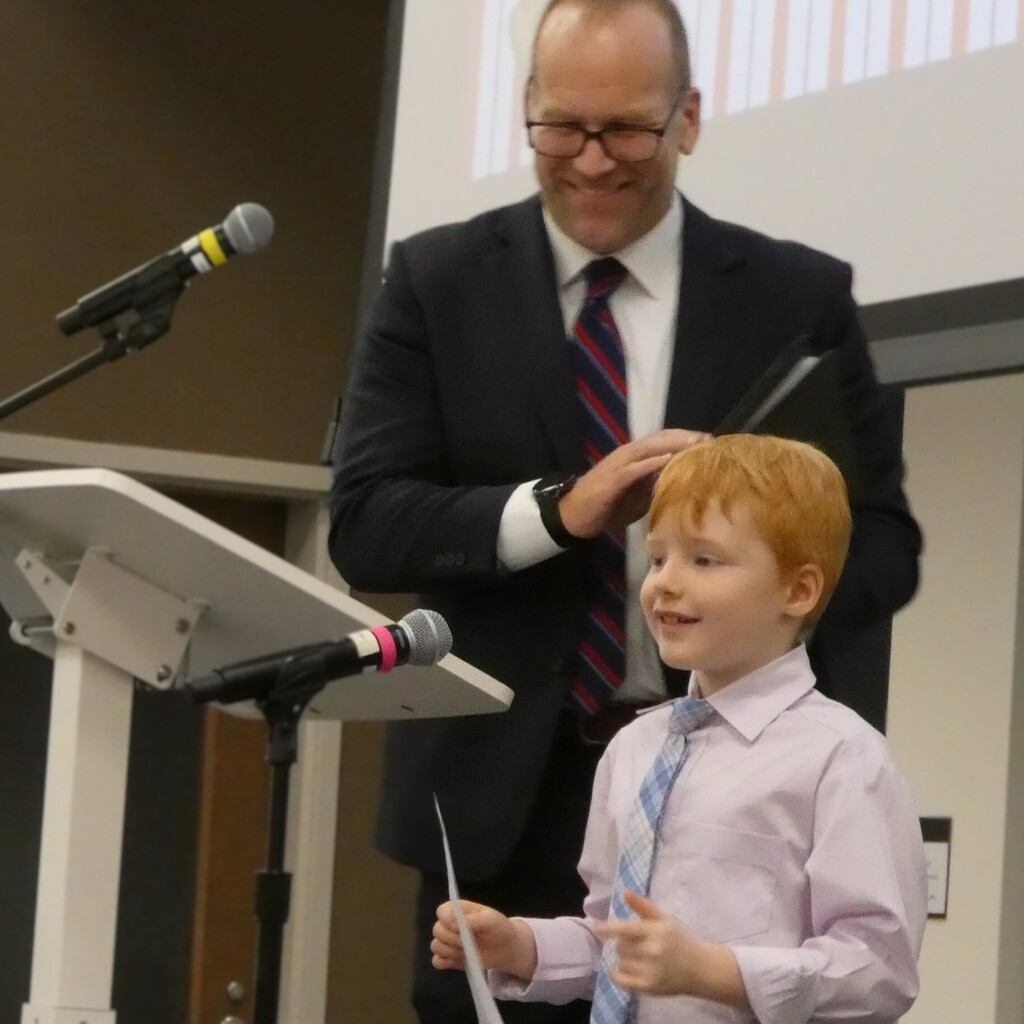 Superintendent applauds as student smiles at end of speech
