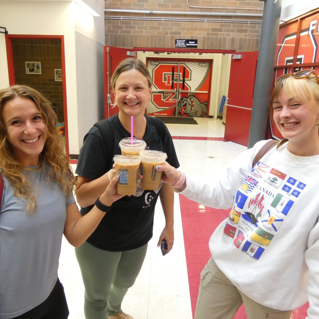 Smiling teachers toast with free coffee