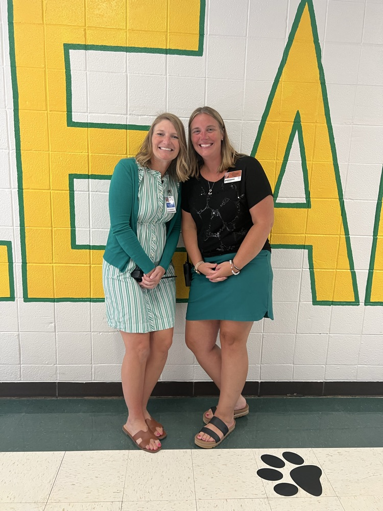 Dr. Gruntman and Mrs. Silverberg standing in front of the “We are Leaders” wall at SPE.