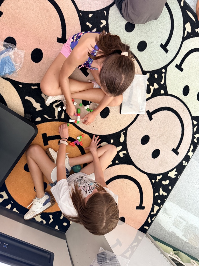 Two students are working in math groups on the rug.