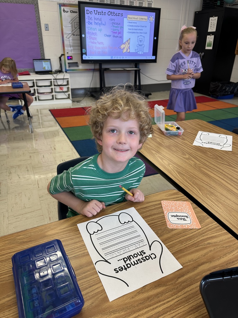 A boy is sitting at his desk. He has a worksheet in front of him that says Classmates should...
