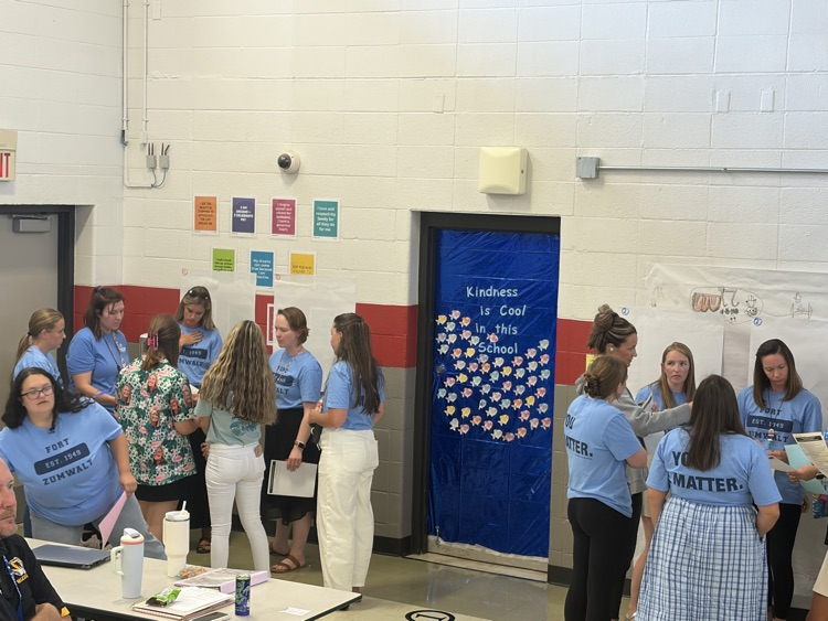 educators in blue shirts working on posters