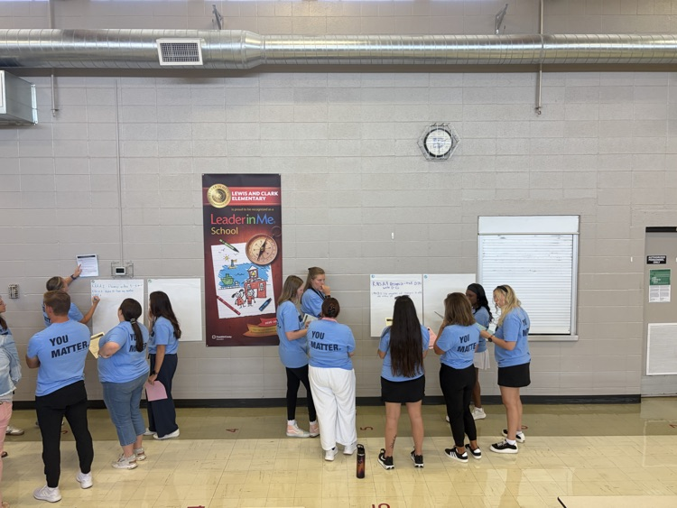 educators in blue shirts working on posters