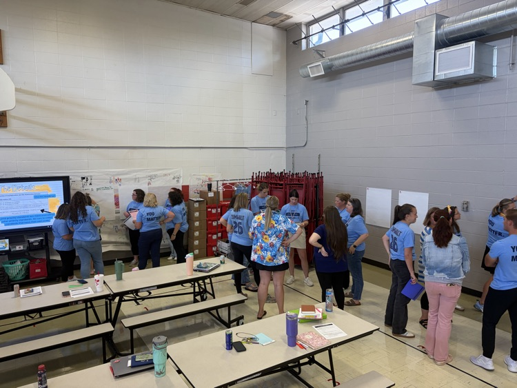 educators in blue shirts working on posters