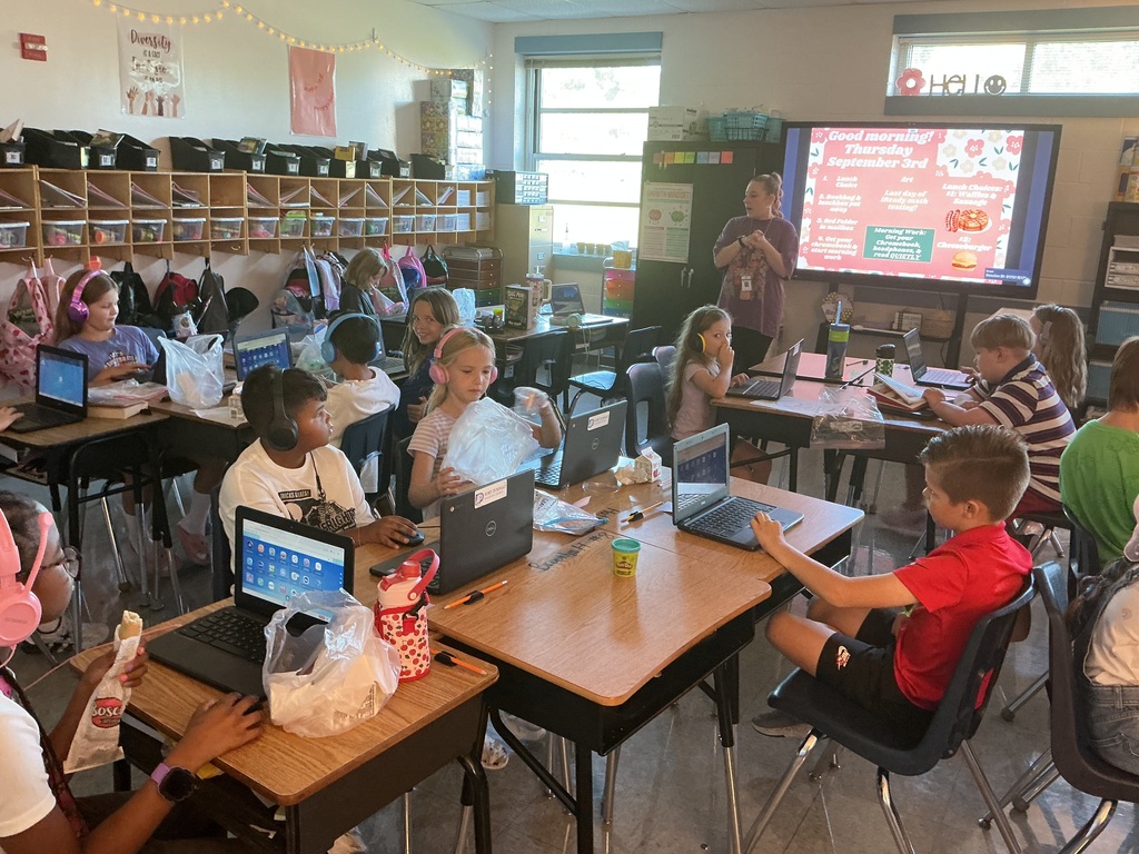 Students at their desks getting ready for testing with their teacher.