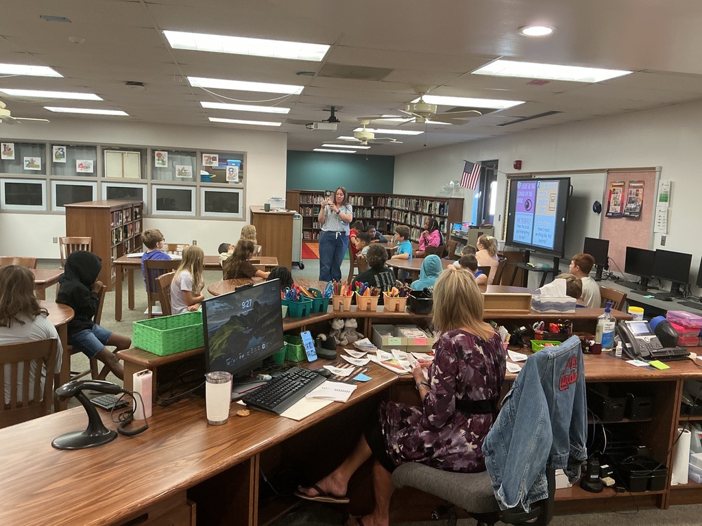 Students in library class listening to their teacher.