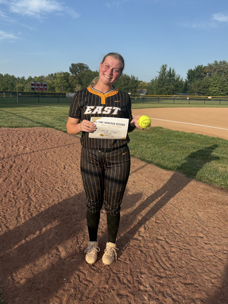Bella holding her home run ball and certificate  