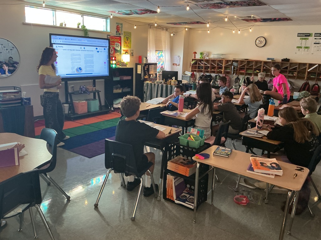 A teacher presenting a lesson to a classroom full of students.