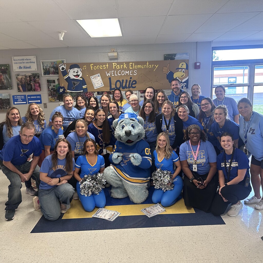 School staff poses with Blues Mascot