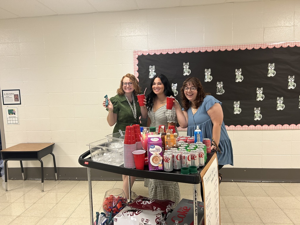 Teachers drinking coffee and soda out of red cups.
