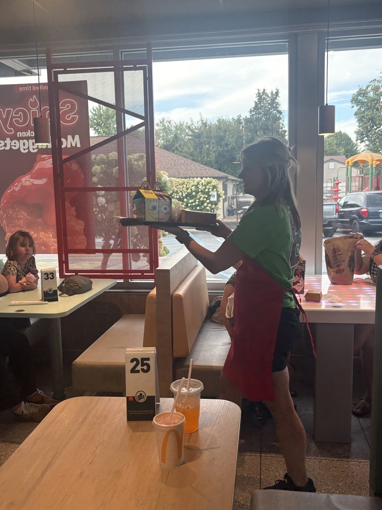 A teacher serving food to students at a restaurant.