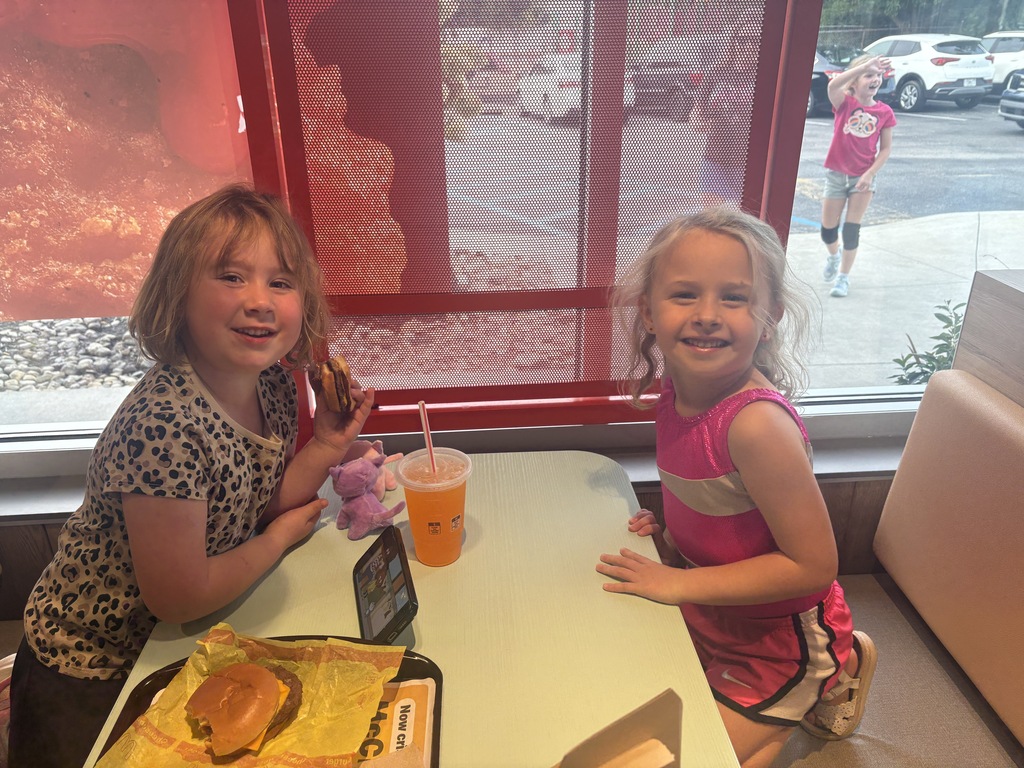 Two girls eating food at a restaurant.