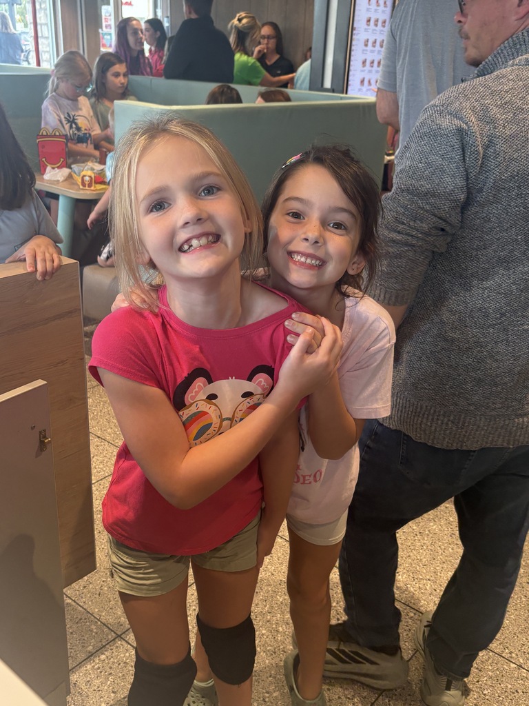 Two girls waiting in line at a restaurant.