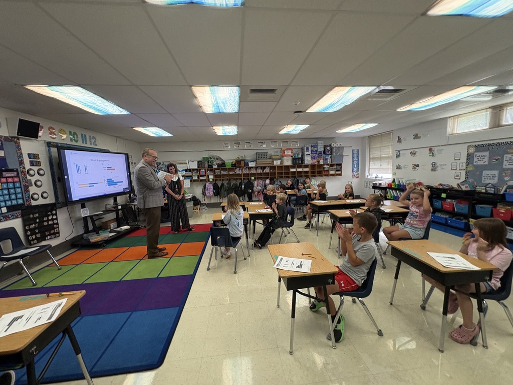 A man speaking to a classroom full of students.