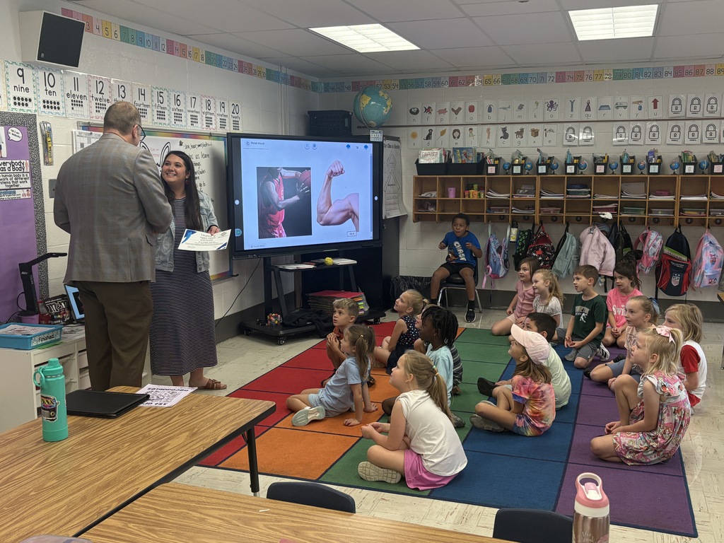 A man speaking to a classroom full of students.