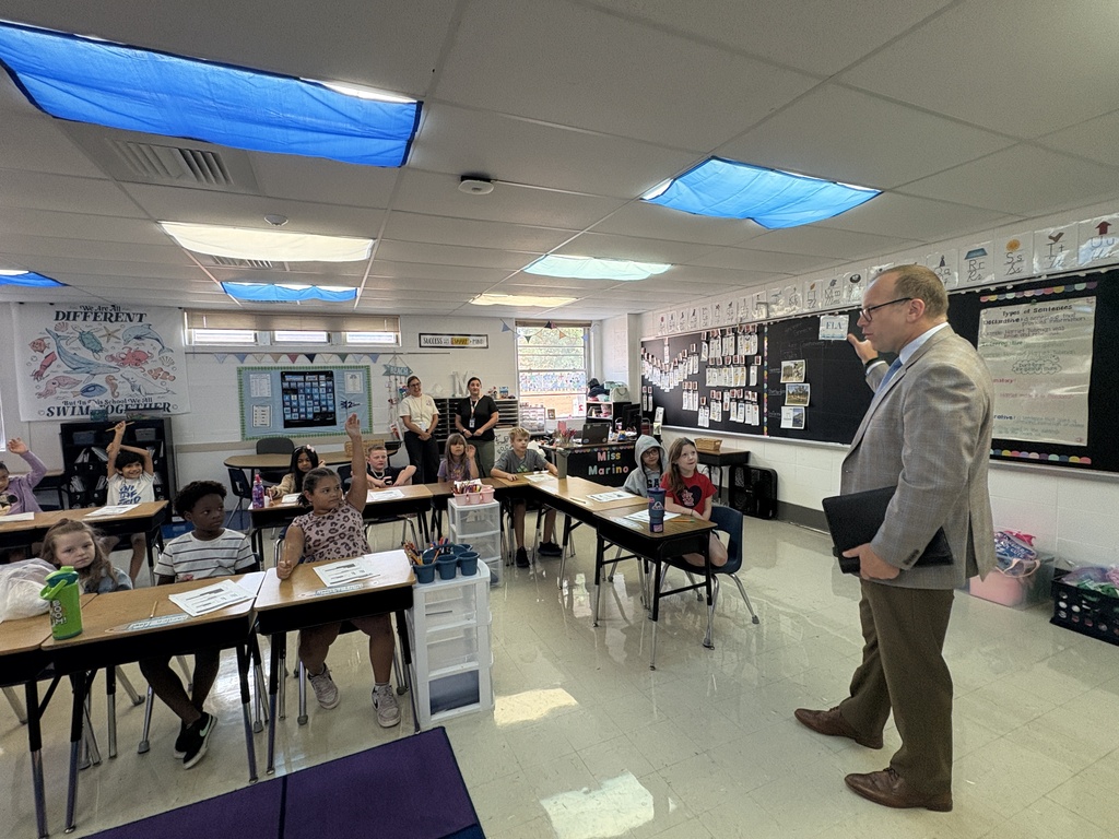 A man speaking to a classroom full of students.