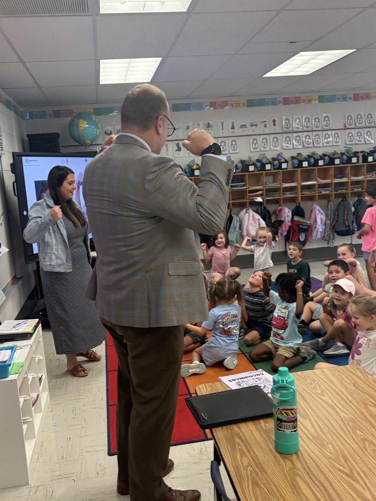 A man speaking to a classroom full of students.