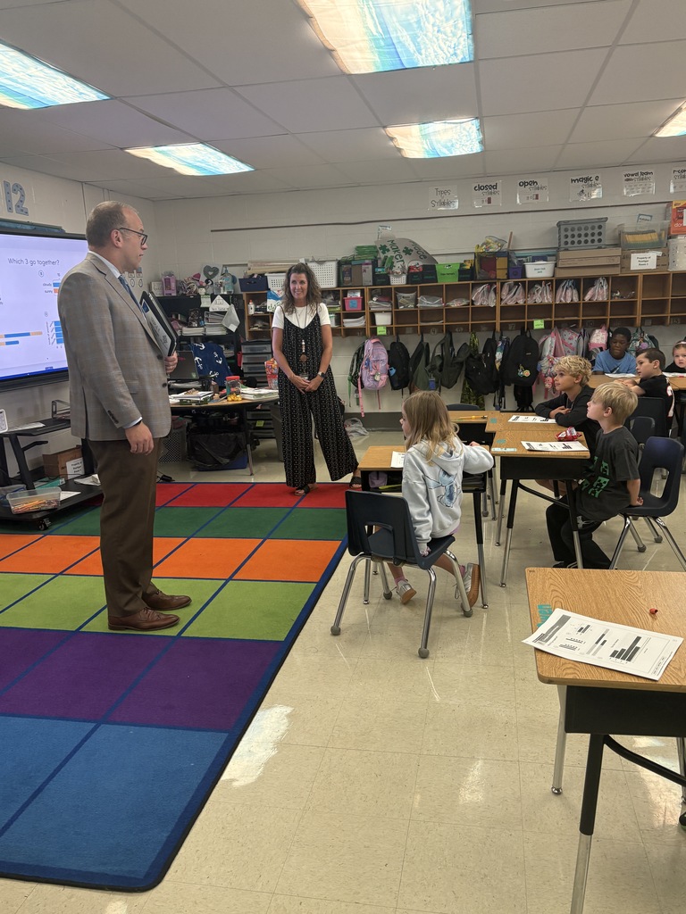 A man speaking to a classroom full of students.