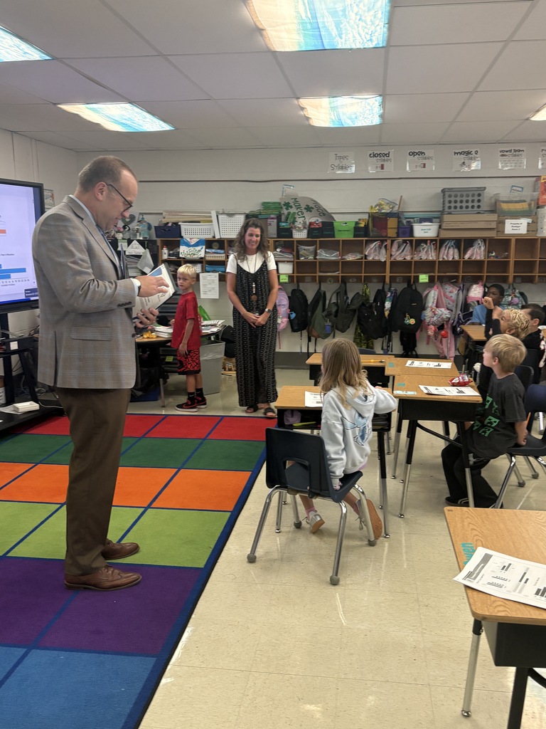 A man speaking to a classroom full of students.