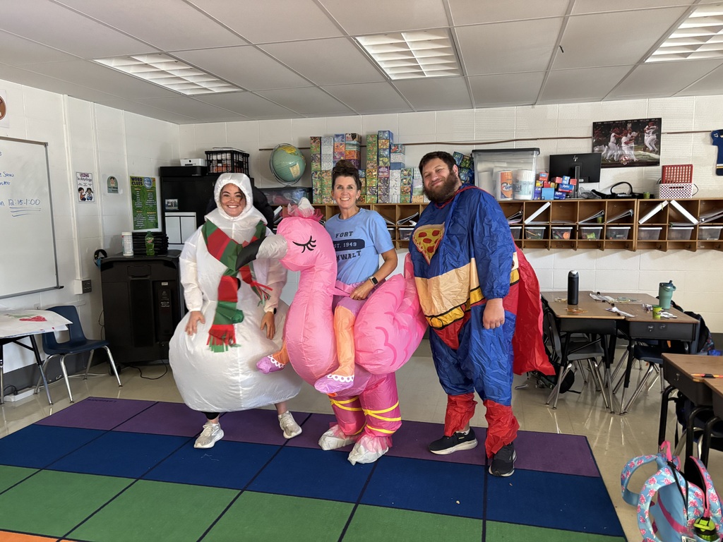 Teachers in costumes in a classroom getting ready for a fun run.