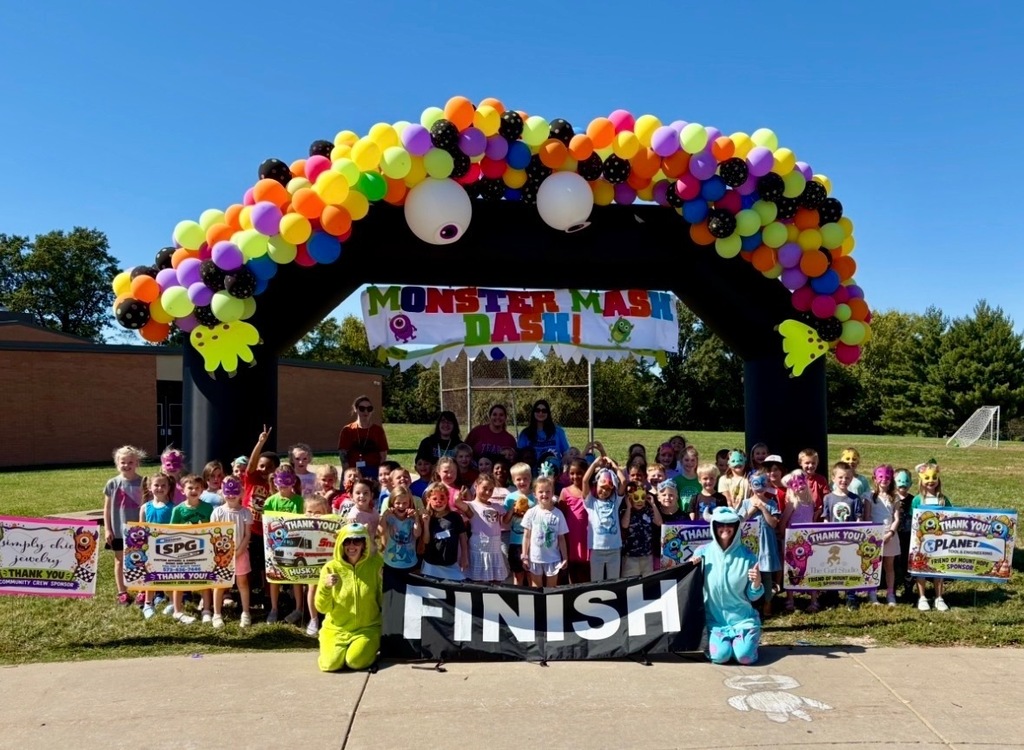 Adults helping students outside during a race. Everyone is dressed in costumes.