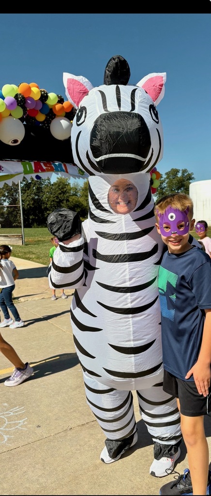 Adults helping students outside during a race. Everyone is dressed in costumes.