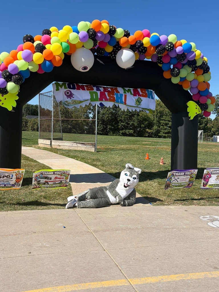 Adults helping students outside during a race. Everyone is dressed in costumes.