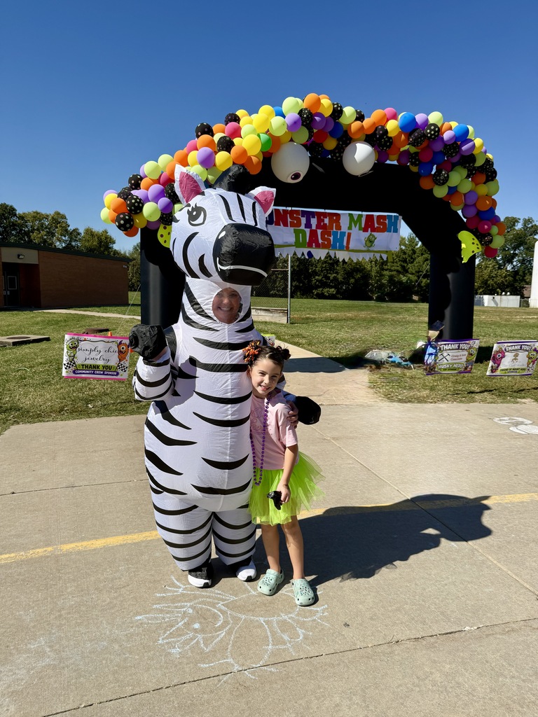 Adults helping students outside during a race. Everyone is dressed in costumes.