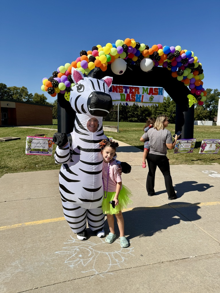 Adults helping students outside during a race. Everyone is dressed in costumes.