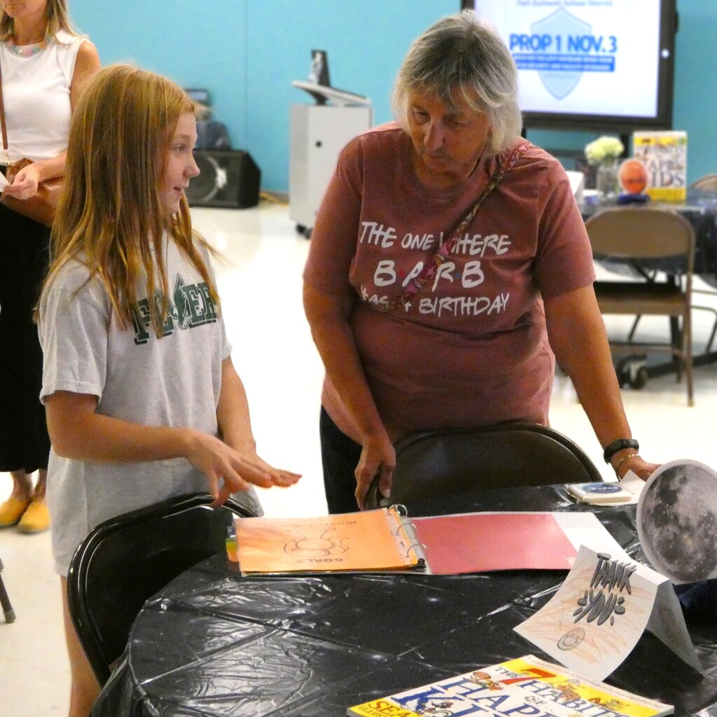 Student shares leadership binder with guest