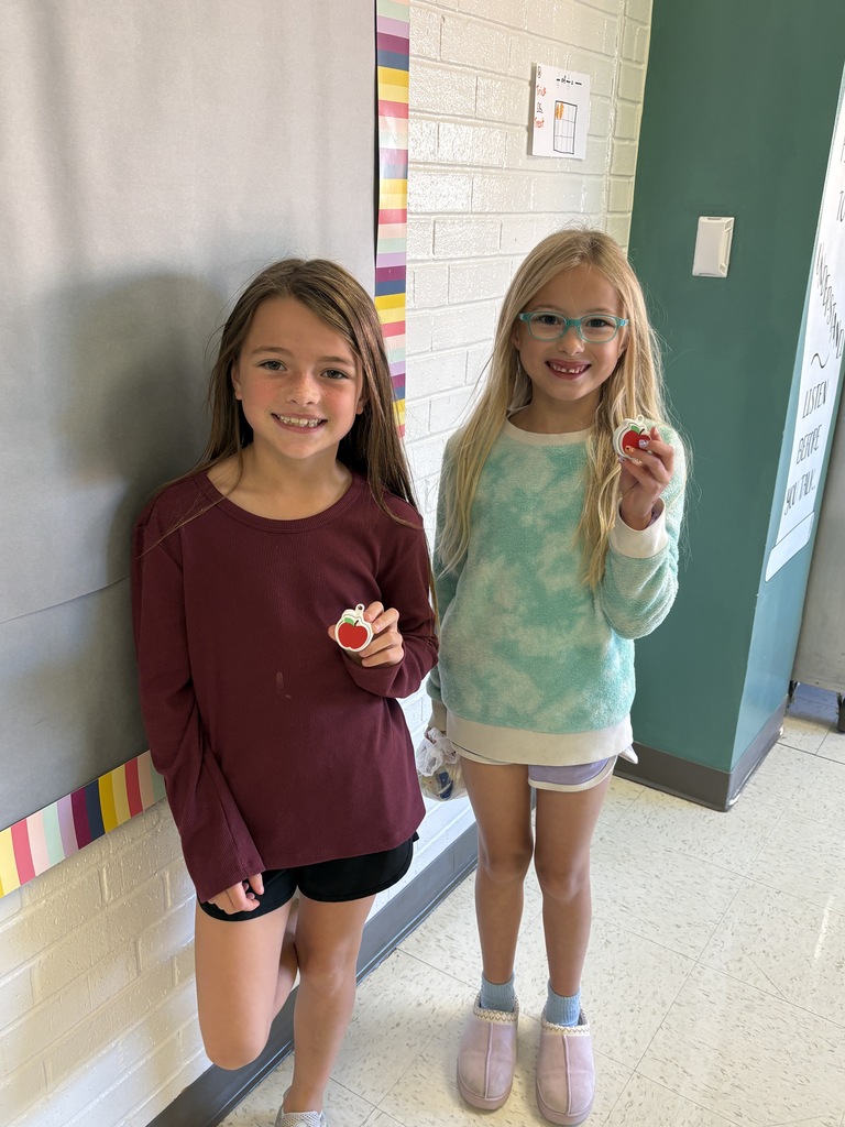Students holding up apples.