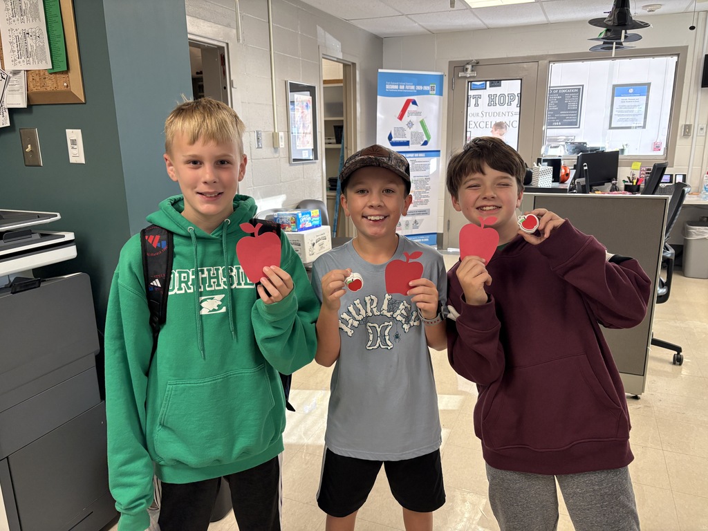 Students holding up apples.