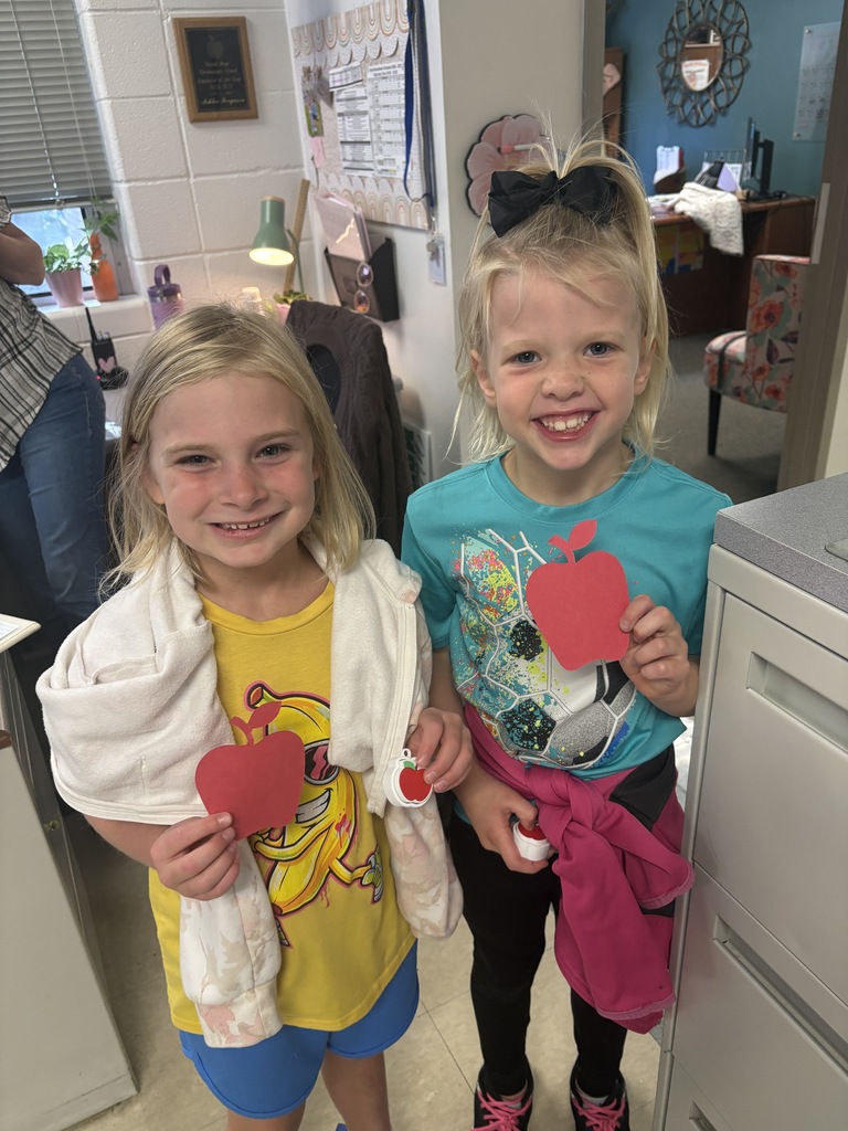 Students holding up apples.