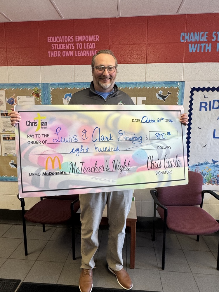 a man in khakis holding a large check for $800!